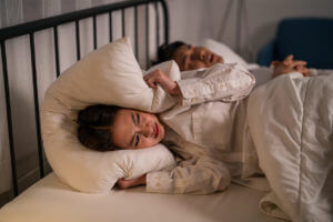 Asian woman feel frustrated from husband snoring while sleep at night